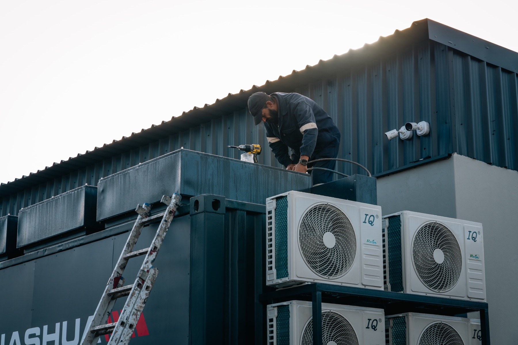 Technician installing rooftop equipment on the Nashua Vryburg container