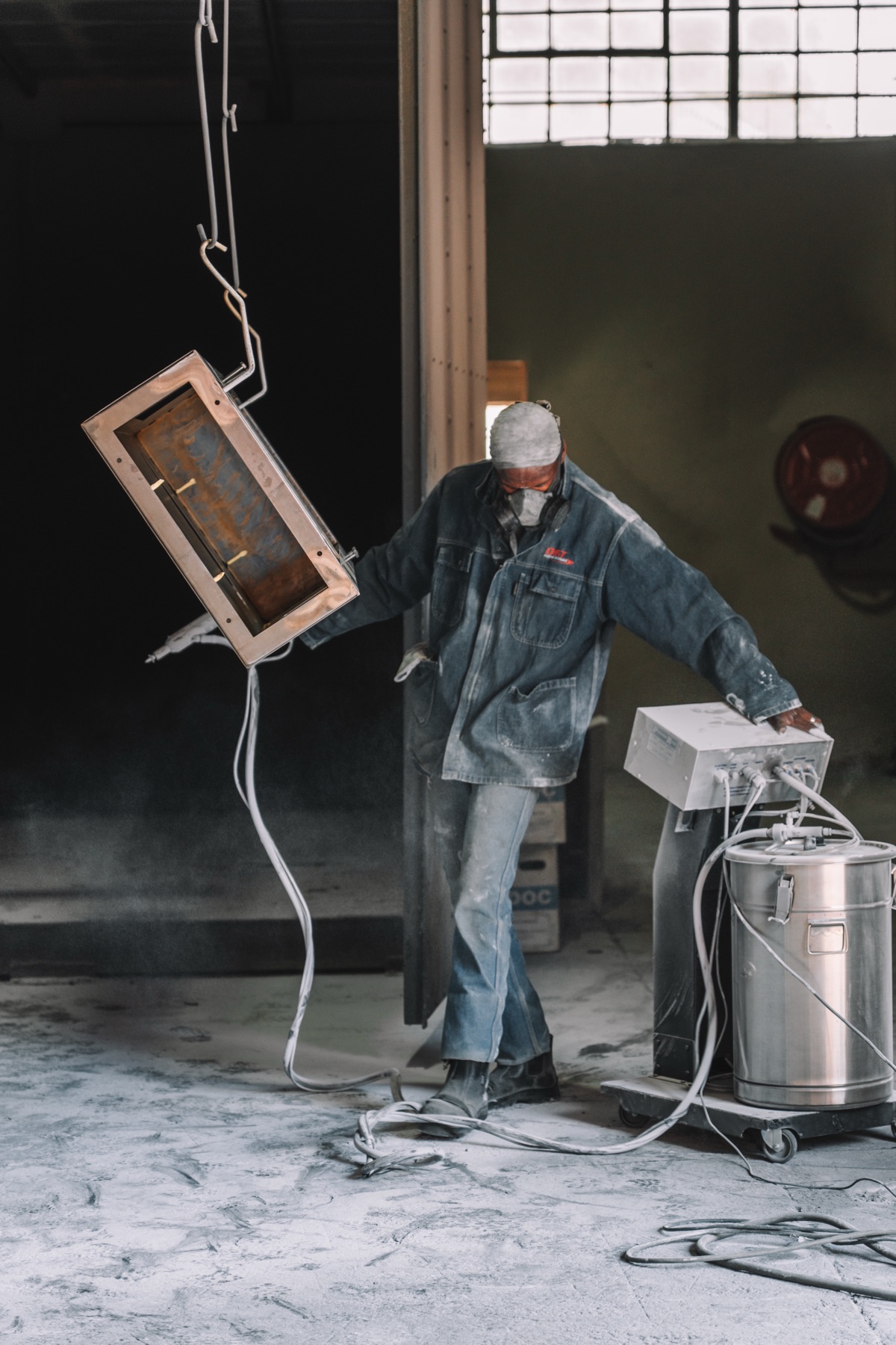 Technician powder-coating a fabricated enclosure