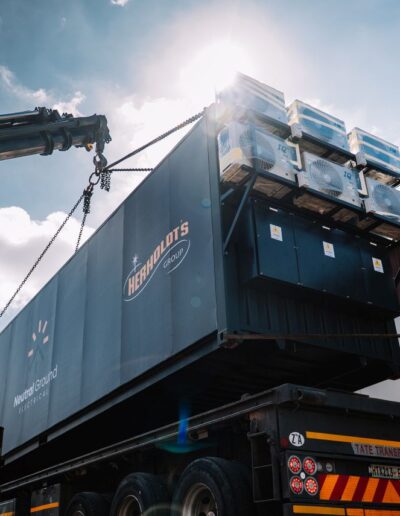 Crane moving a container under a blue sky
