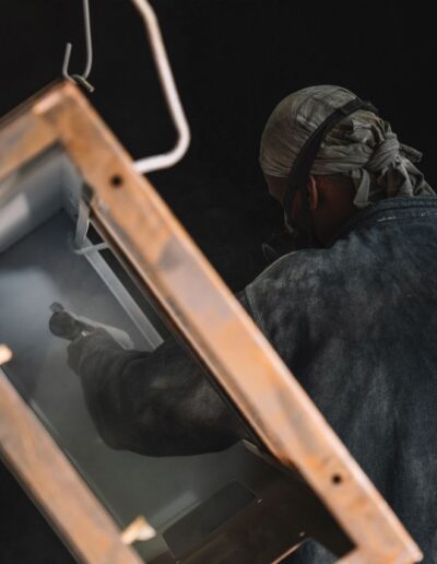 A worker painting a metal frame