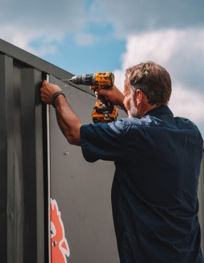 Industrialec engineer drilling a hole into a metal panel