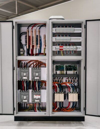 Industrial electrical cabinet with open doors, showing internals.