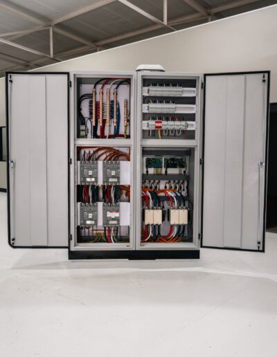 Industrial electrical cabinet with open doors, showing internals.