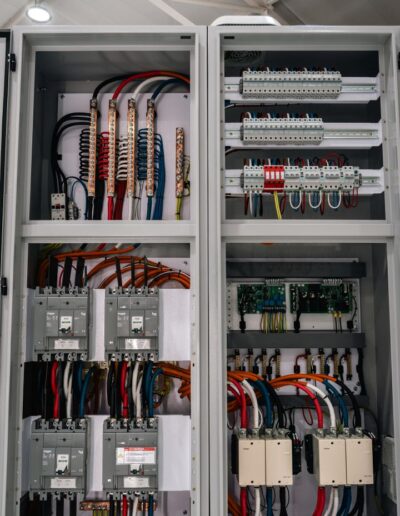 Close-up of industrial electrical cabinet with open doors, showing internals.