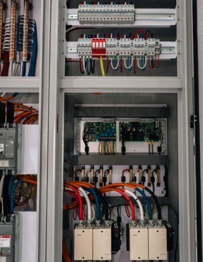 Close-up of industrial electrical cabinet with open doors, showing internals.