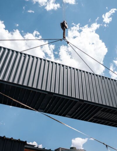 A crane moving a container under a blue sky