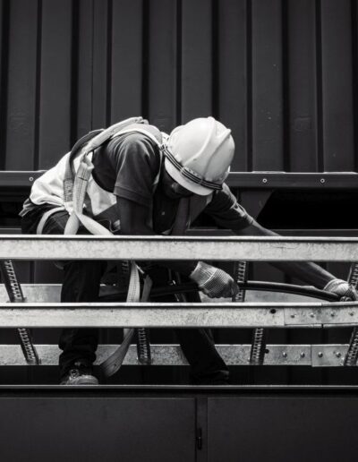 Greyscale image of a man with PPE pulling a cable