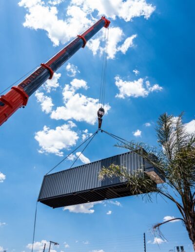 A large crane moving a container under a blue sky