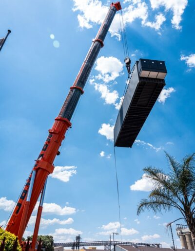 A large crane moving a container under a blue sky