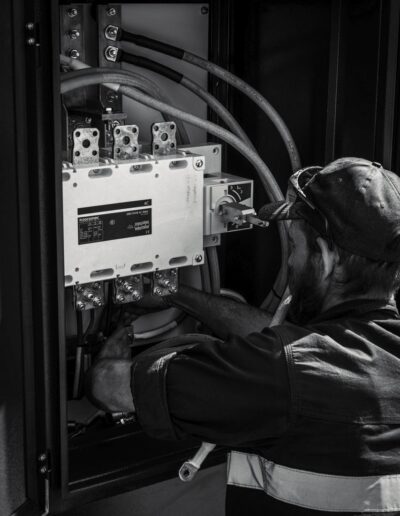 Greyscale image of an engineer working on an electrical cabinet